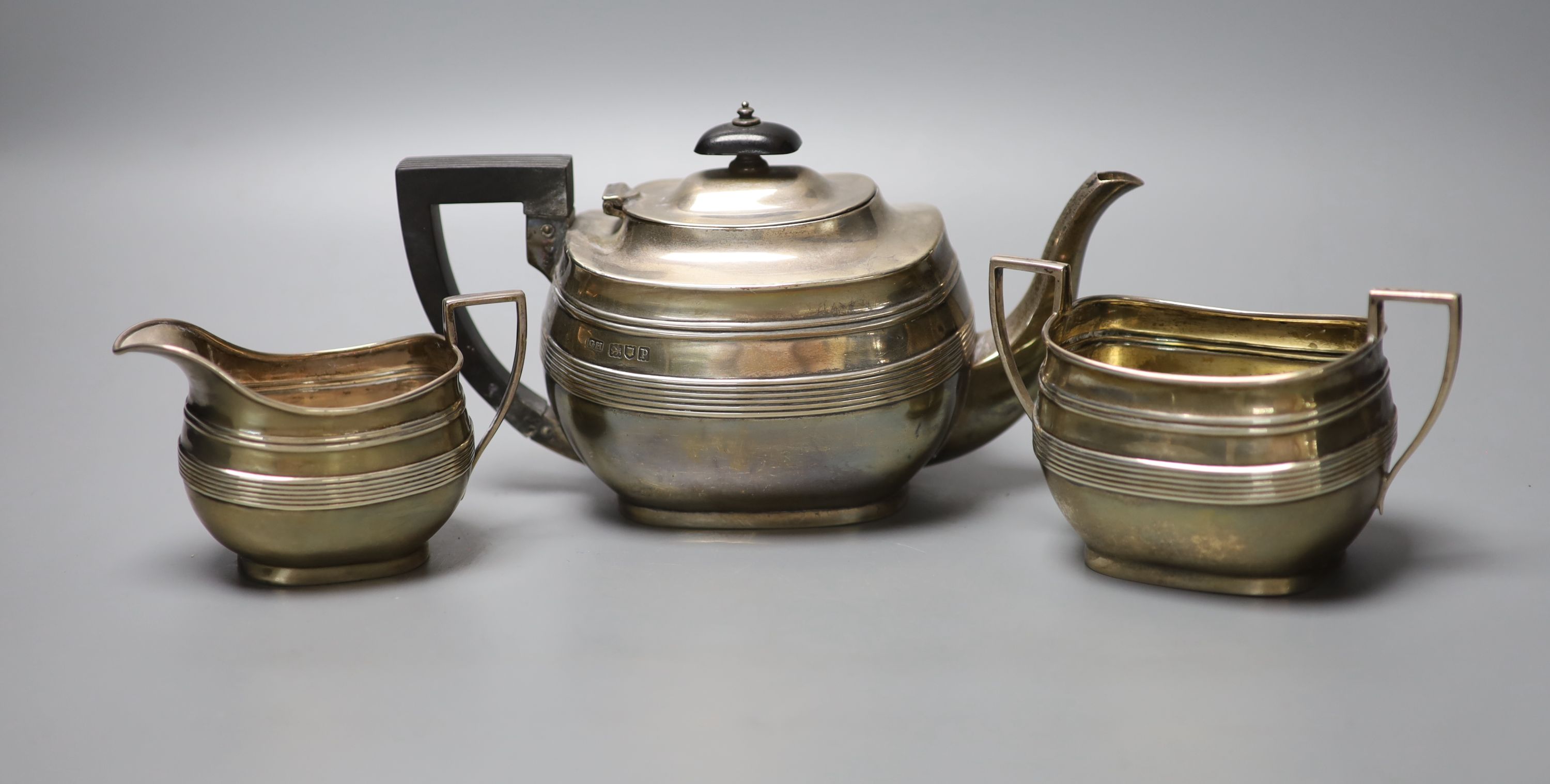 A George V reeded silver oval three piece tea set, George Howson, London, 1910, gross 16oz.